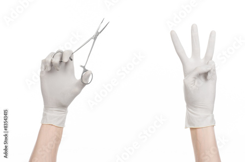 doctor's hand in white glove holding a surgical clamp with swab