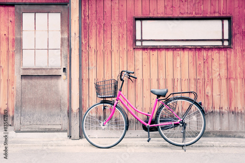 Pink bicycle and old wood walls.