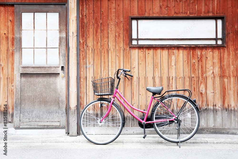 Pink bicycle and old wood walls.