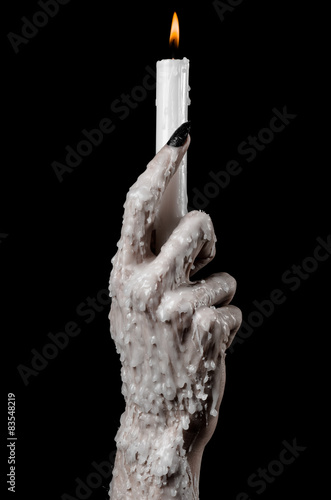 hands holding a candle, a candle is lit, black background