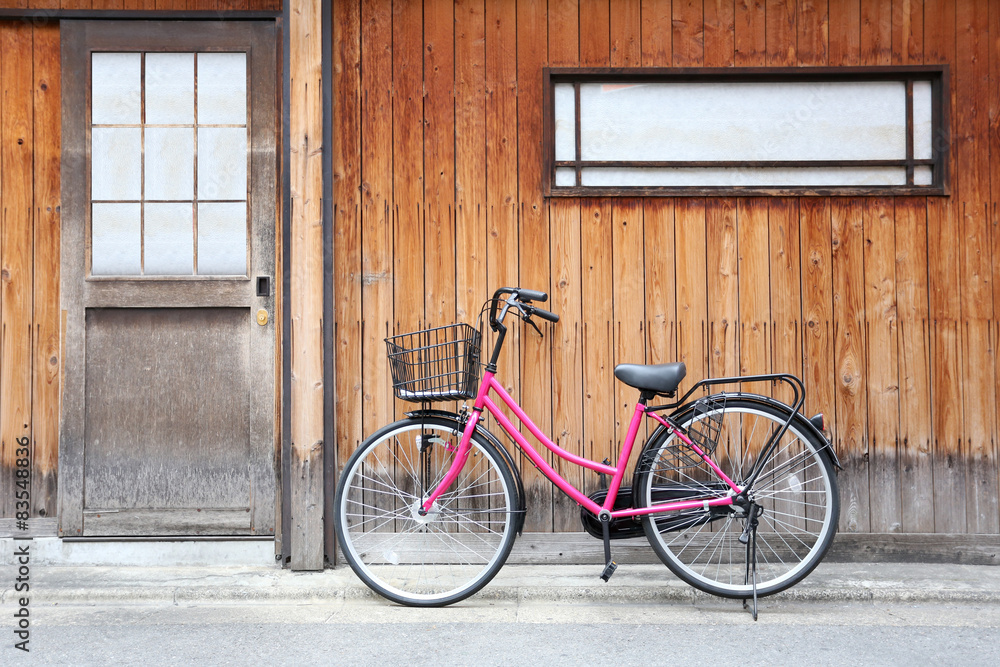 Pink bicycle and old wood walls.