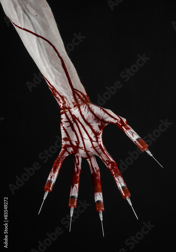 Bloody hand with syringe on the fingers, toes syringes in studio