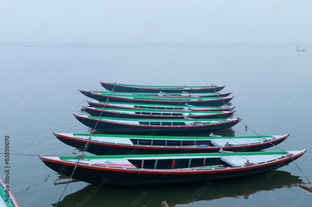 Boats in a row on sacred river Ganges foggy morning. Varanasi