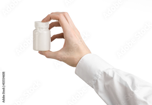 doctor's hand holding a white empty jar of pills studio isolated