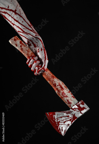 bloody hand holding a bloody butcher's ax isolated in studio