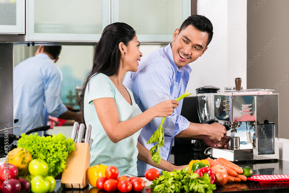 Asian couple cooking food together in kitchen Asian couple cooking food together in kitchen