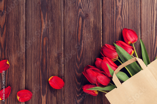 Fototapeta Naklejka Na Ścianę i Meble -  Red tulips bouquet in paper bag