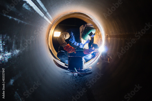 Workers welding work at night in the pipeline.