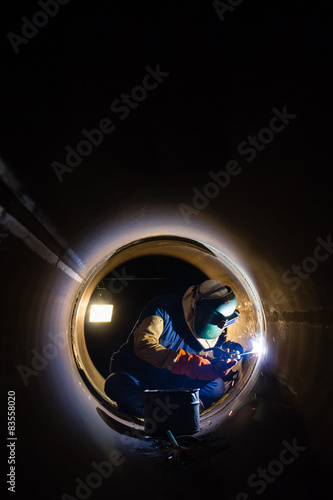 Workers welding work at night in the pipeline.