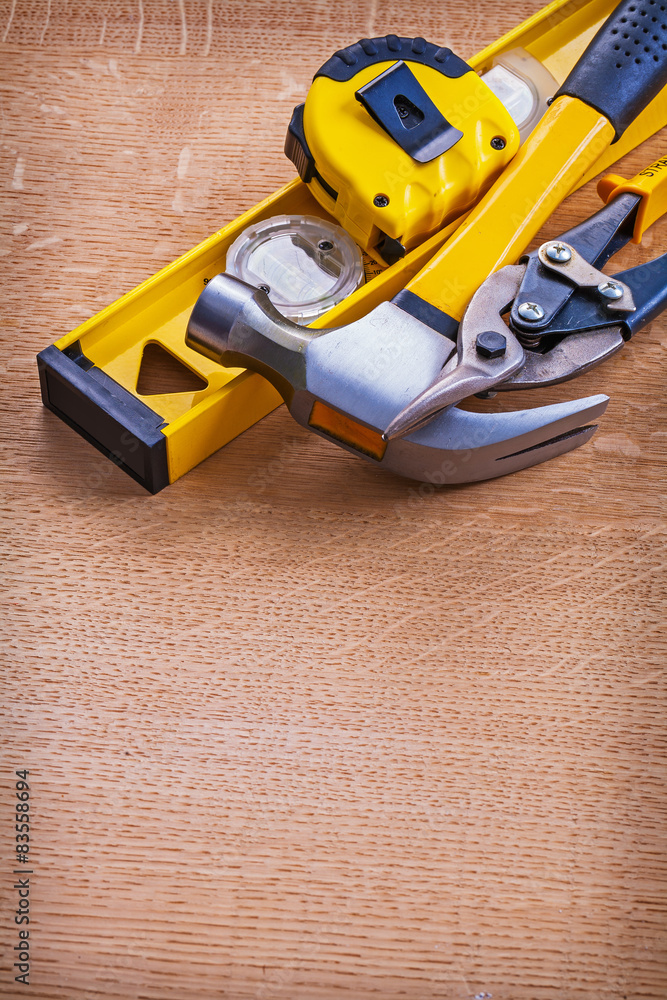 Obraz premium Claw hammer construction level nippers and tape measure on woode