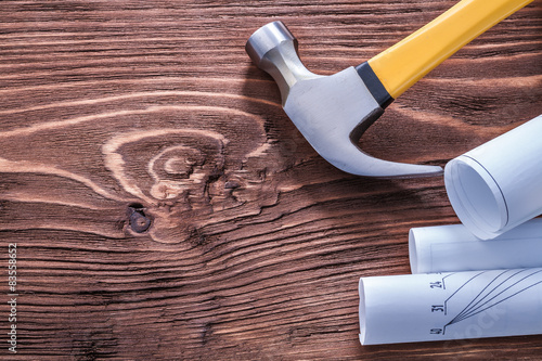 Claw hammer and blueprints on brown vintage wooden board constru photo