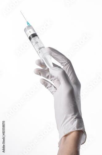 Doctor's hand holding a syringe, white-gloved hand