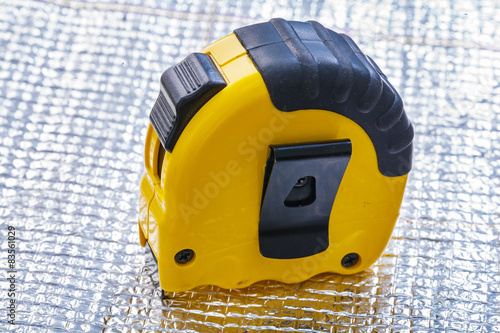 Yellow tape measure on metal background construction concept