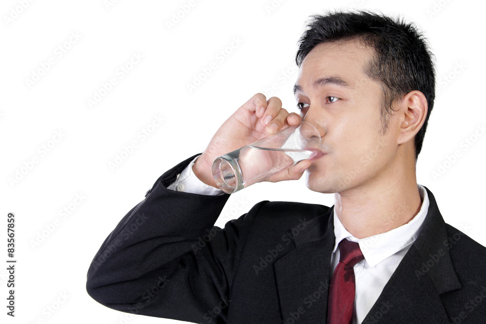 Young businessman drinking a glass of water, isolated on white Young businessman drinking a glass of water, isolated on white