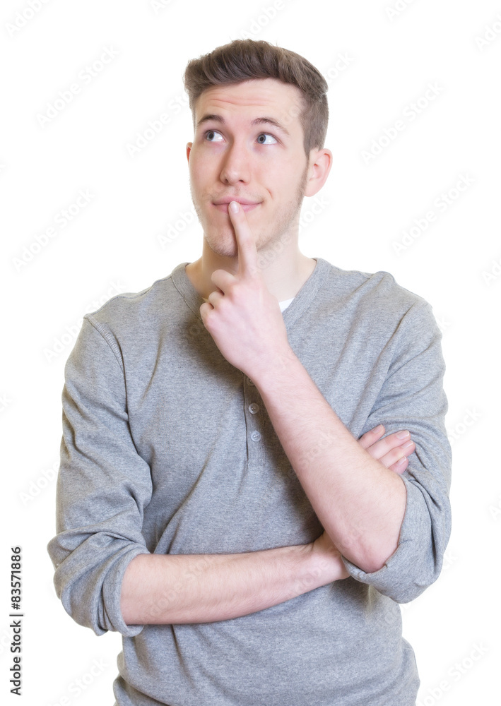 Junger Mann im grauen Shirt schaut verträumt Junger Mann im grauen Shirt schaut verträumt