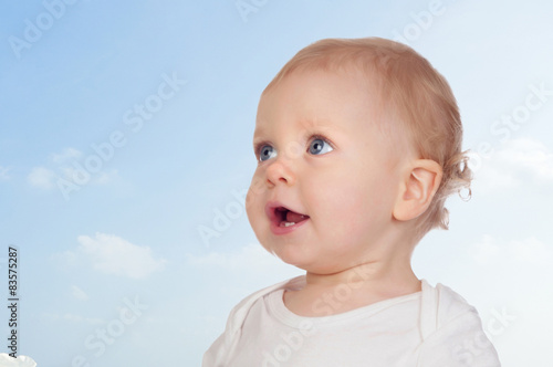 Nice baby with blue eyes with a beautiful sky