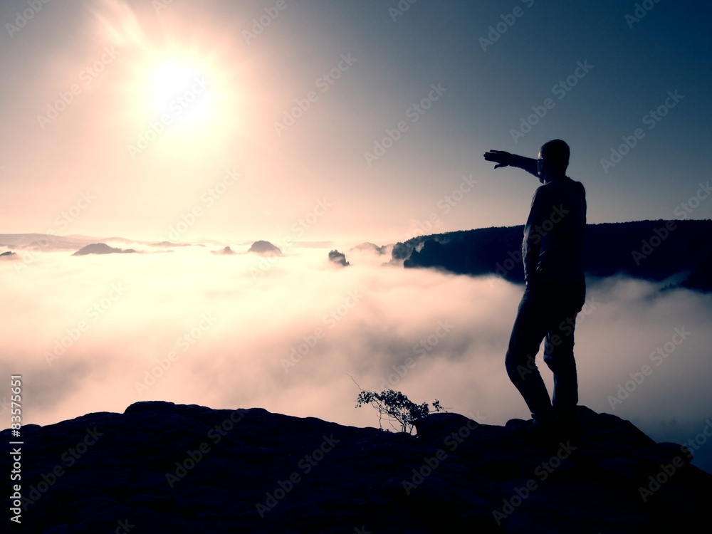 Man stand on peak of rock empire and watch into nature miracle 