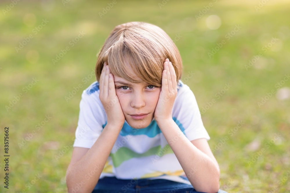 Obraz premium Little boy feeling sad in the park