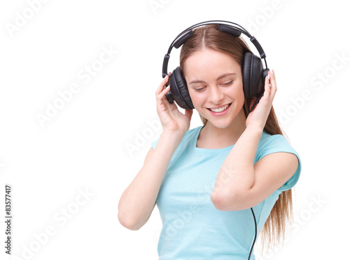 Young woman with headphones listening to music and dancing.