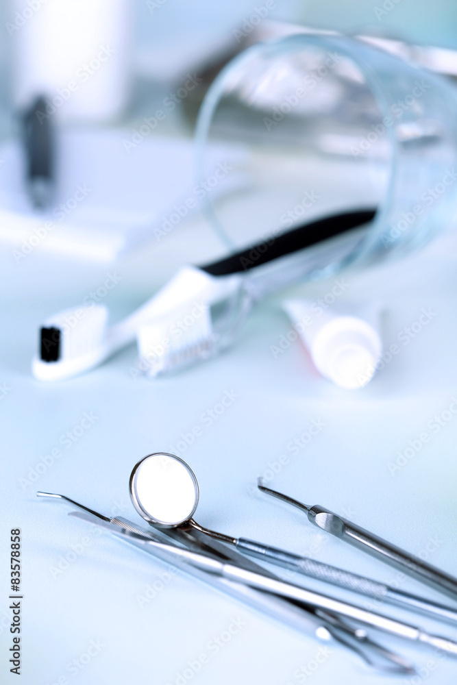 Dentist tools with toothpaste and brushes on table close up Dentist tools with toothpaste and brushes on table close up