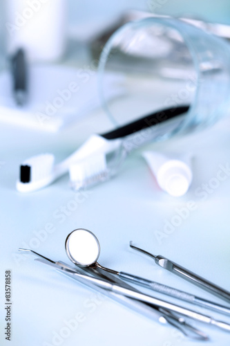 Dentist tools with toothpaste and brushes on table close up