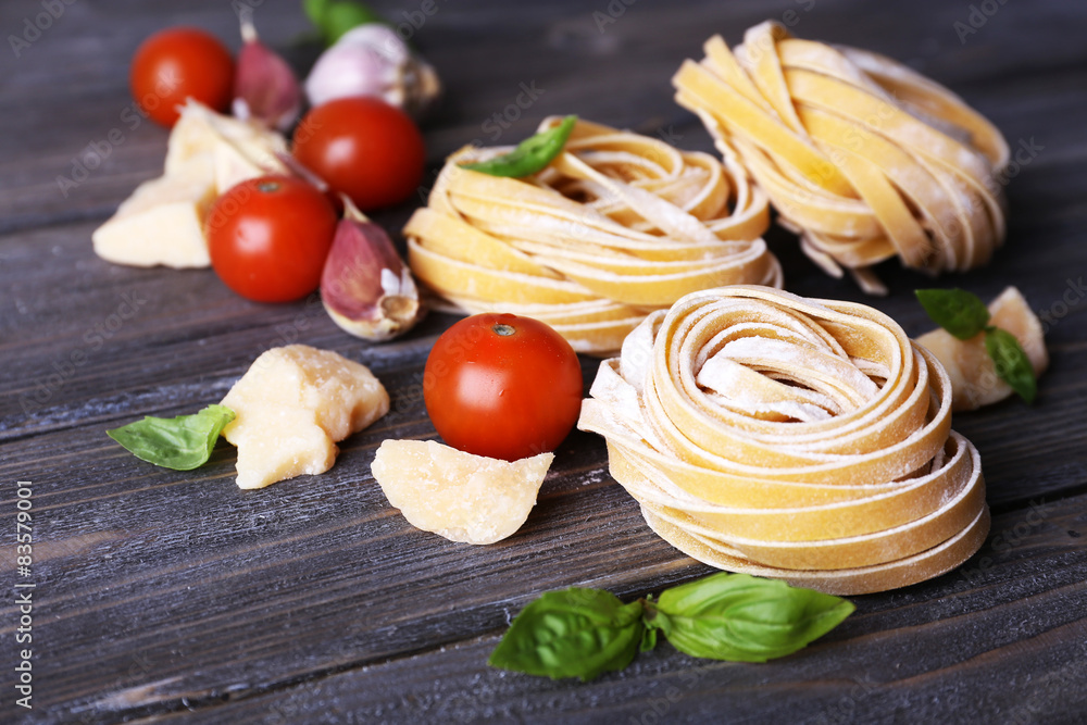 Raw homemade pasta with cheese and vegetables on wooden background Raw homemade pasta with cheese and vegetables on wooden background