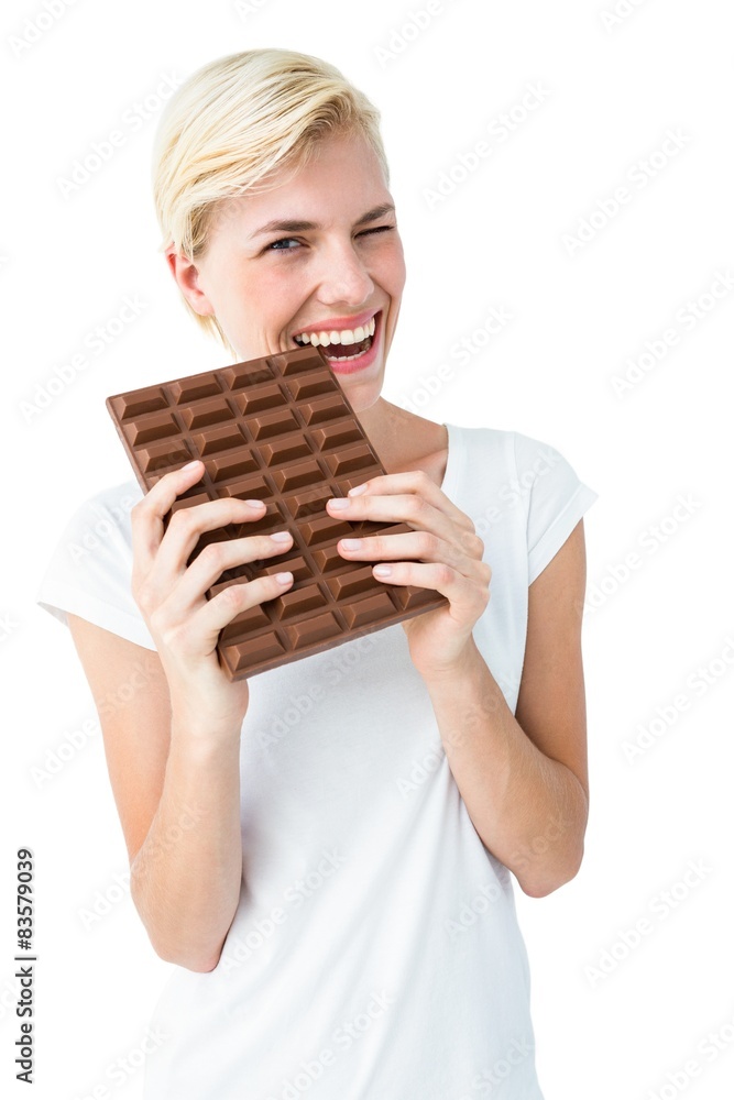 Attractive woman biting bar of chocolate