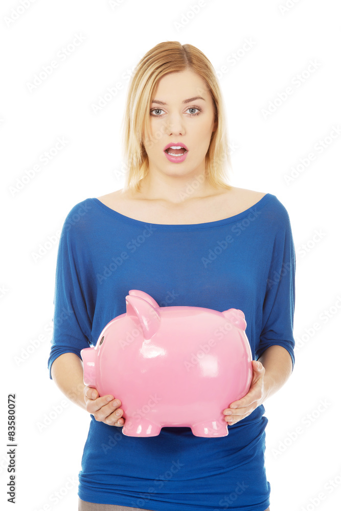 Shocked woman holding piggybank. Shocked woman holding piggybank.