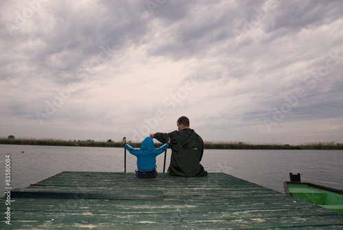 Dad and son on the lake under a gloomy sky photo