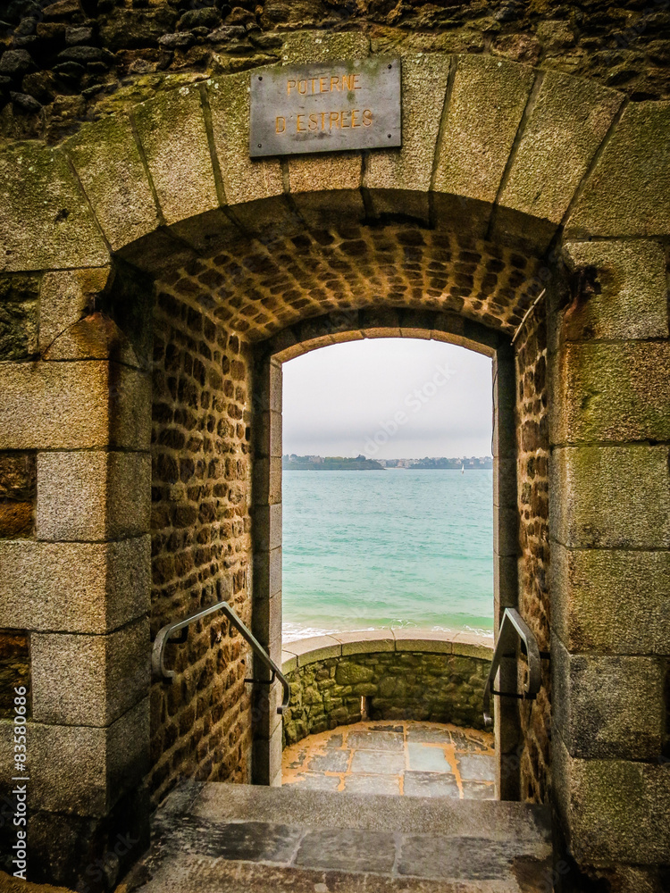 Obraz premium View of the sea through a door in a wall