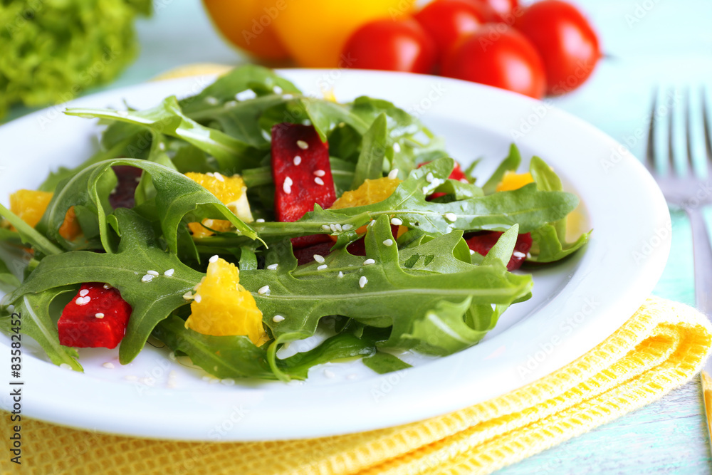 Tasty salad with arugula leaves in plate on wooden table, closeup