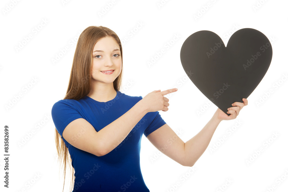 Happy teenager pointing on paper heart. Happy teenager pointing on paper heart.