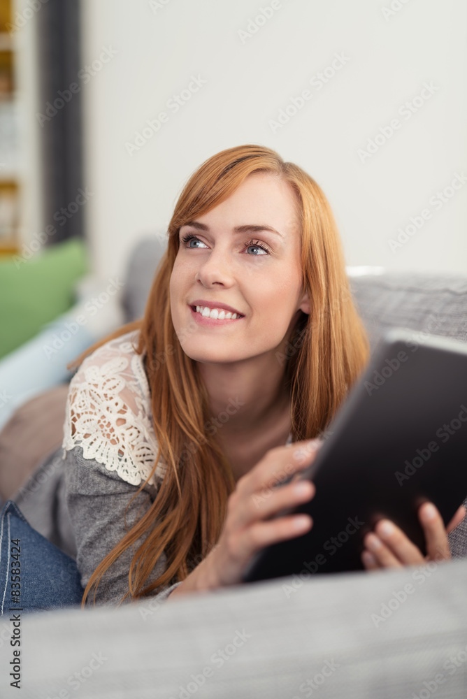 entspannte junge frau mit tablet-pc zuhause auf dem sofa entspannte junge frau mit tablet-pc zuhause auf dem sofa