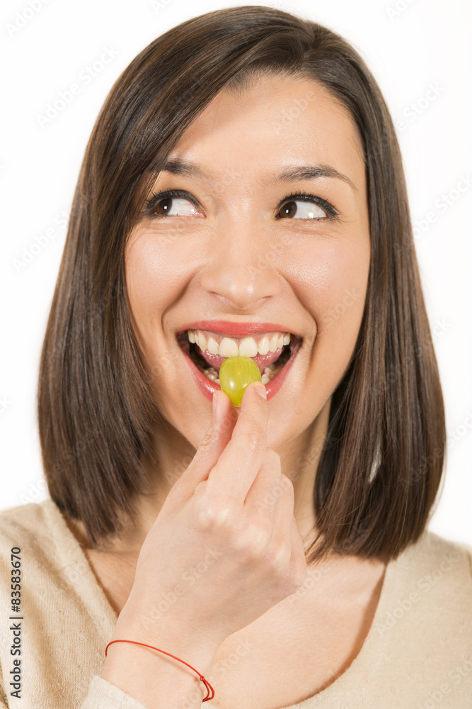 Portrait of young woman eating white grape Portrait of young woman eating white grape