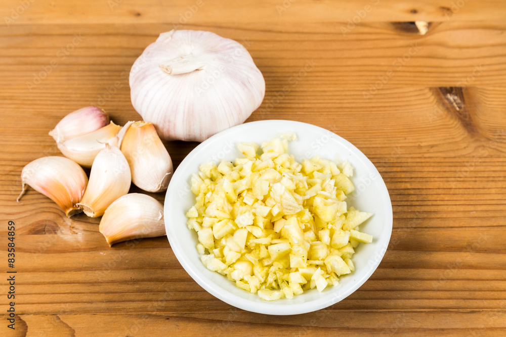 Chopped garlic in a plate with garlic bulb and cloves Chopped garlic in a plate with garlic bulb and cloves
