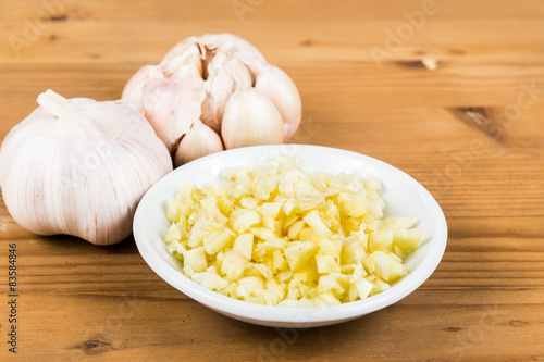 Chopped garlic in a plate with garlic bulb and cloves 