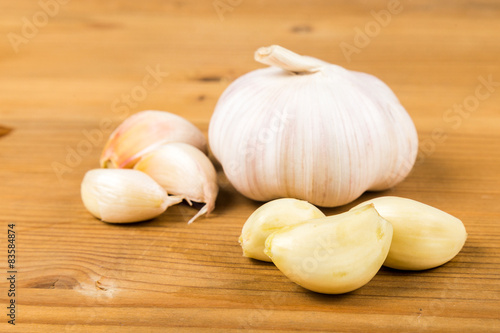 Peeled garlic cloves with garlic bulb and cloves as background