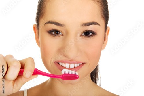 Young woman brushing her teeth.