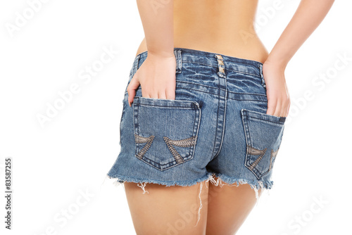 Shirtless woman in jeans shorts.