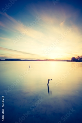 Vintage photo of beautiful sunset over calm lake
