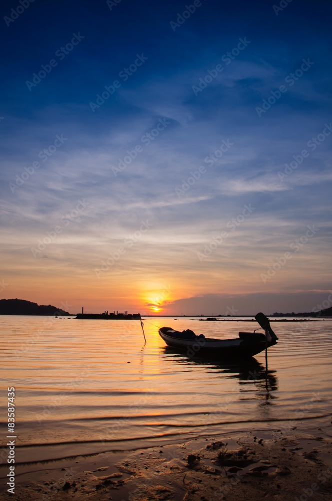 Beautiful silhouette fishing boat in lake at Twilight sky.