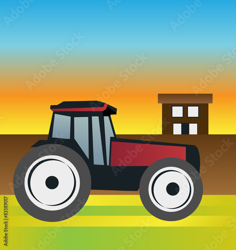 Tractor on the field at sunset with the farm in the background