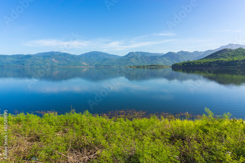 View of reservoir blue sky and green grass © themorningglory