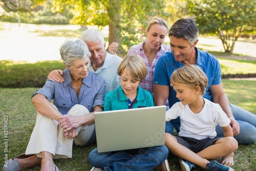 Happy family using laptop in the park