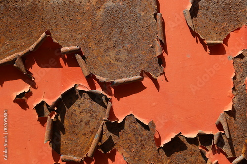 Painted Rusty Metal Surface with curled-up peeling red paint