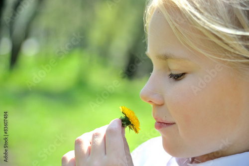 Canvastavla Profile of cute girl with  dandelion looking at it in the park