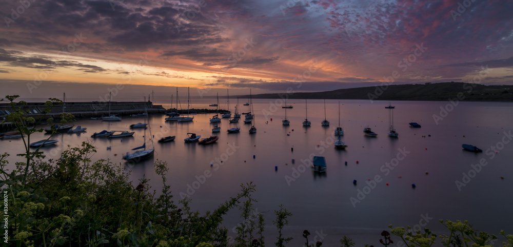 Dawn breaking over a harbour with small boats and yachts