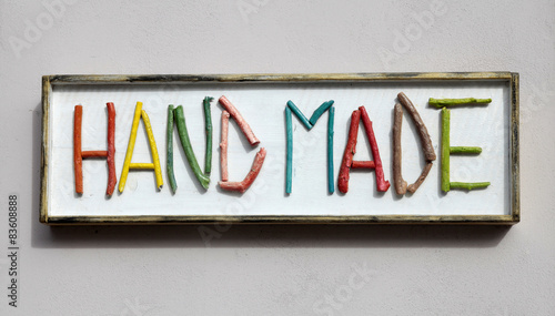 Sign with colorful wooden letters forming word "hand made"