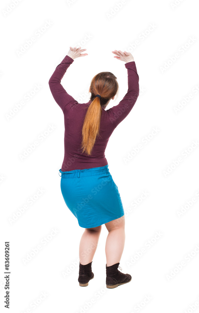 back view of woman protects hands from what is falling from abo back view of woman protects hands from what is falling from abo