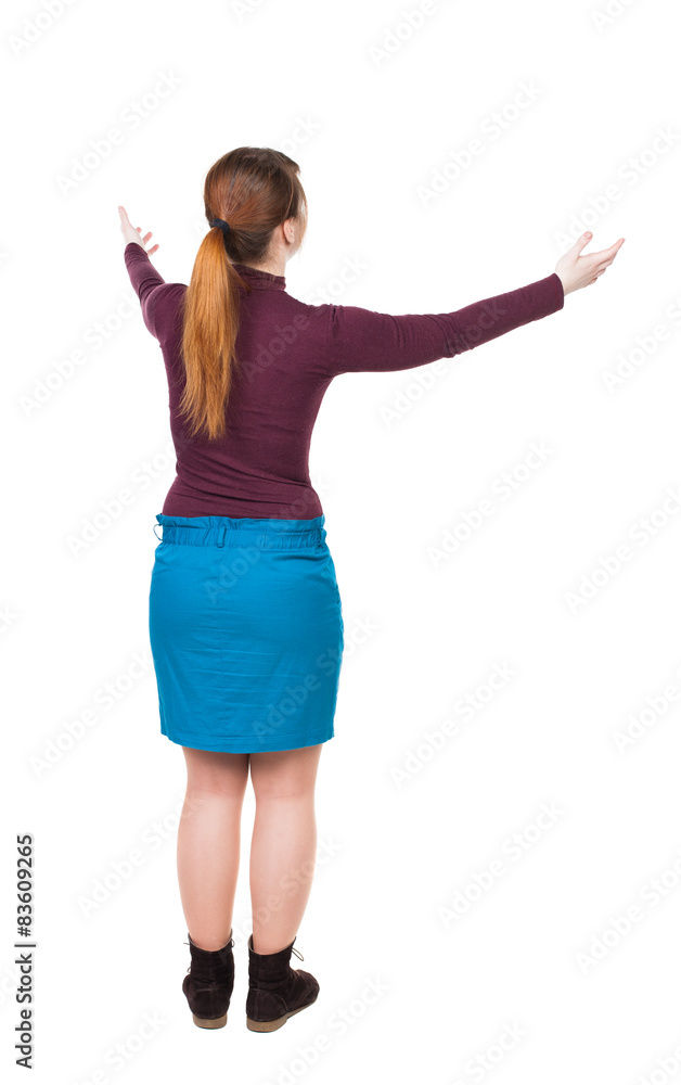 Back view of Beautiful woman in dress looking at wall and Holds Back view of Beautiful woman in dress looking at wall and Holds